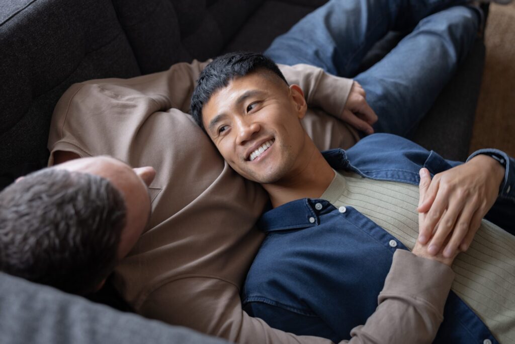 Gay,Couple,At,Home,Relaxing,On,A,Sofa,Together