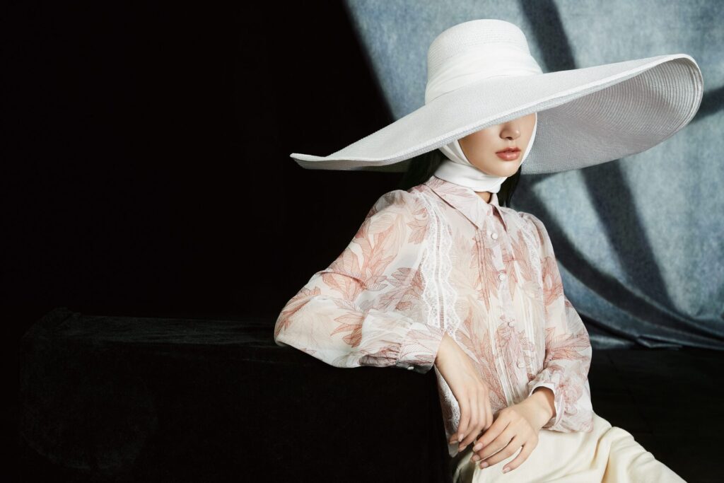 Elegant,Woman,In,Floral,Blouse,And,Oversized,White,Hat,With