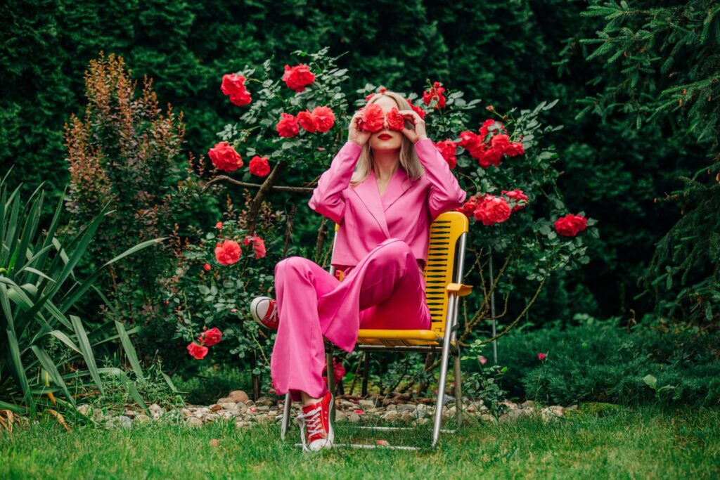 Woman,In,Stylish,Pink,Suit,In,Rose,Garden,Sitting,In