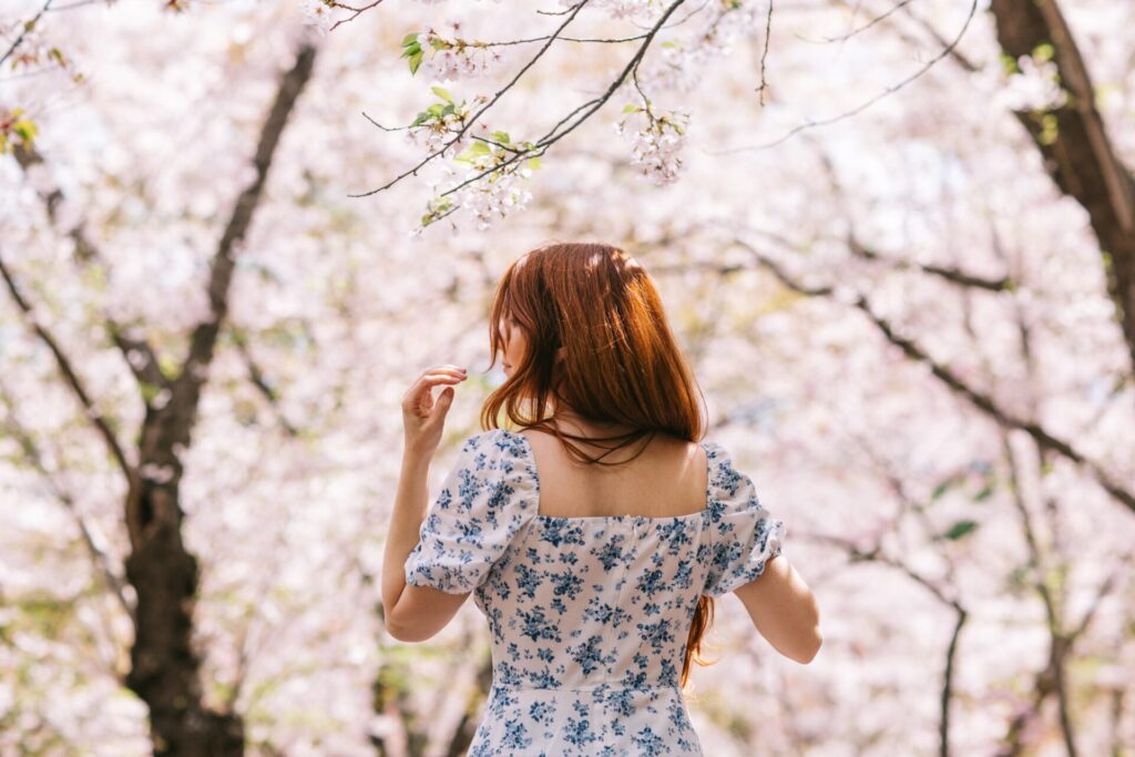 A,Woman,With,Red,Hair,In,A,Floral,Dress,Stands
